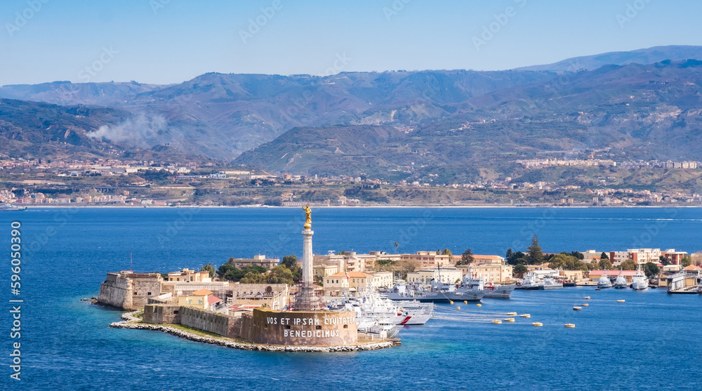 The Strait of Messina between Sicily and Italy. View from Messina town with golden statue of Madonna della Lettera and entrance to harbour. Calabria coastline in background