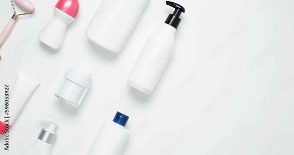 Cosmetic beauty products on white background. Bottles and tubes with branding mock up. Skin care and beauty concept. Top view, flat lay, copy space