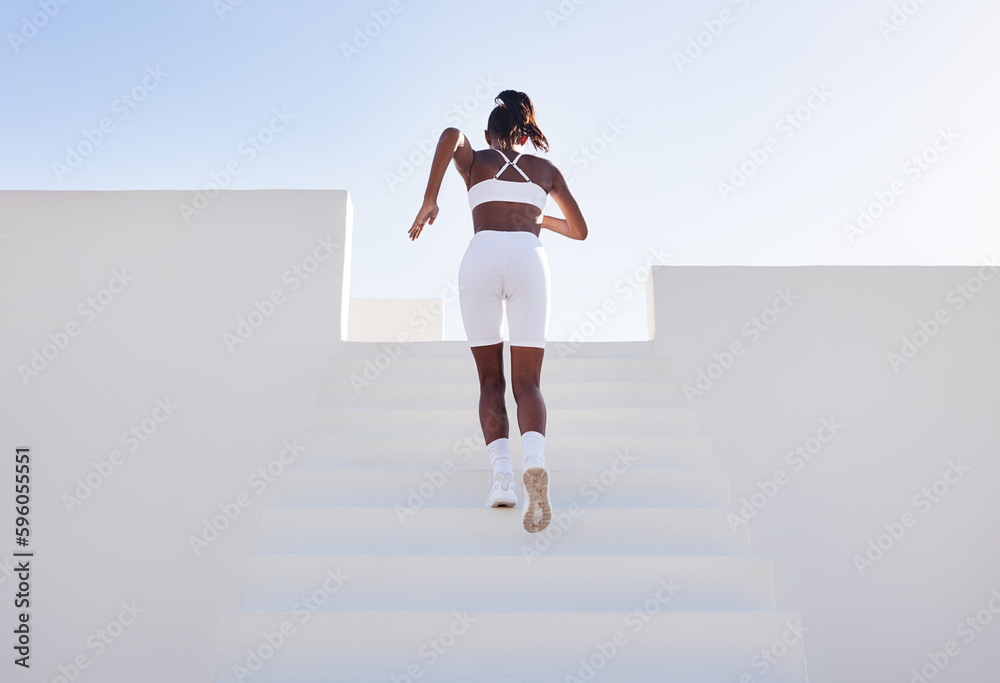 Back view of a woman in white sportswear running up on stairs. Rear view of a young female jogger exercising in a white outdoor studio. - obrazy, fototapety, plakaty 