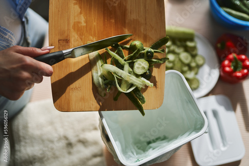 Woman throwing organic food waste in a compost bin. Female person recycling compostable leftovers in a bokashi container