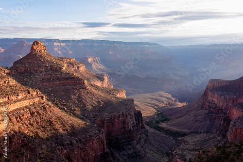 Panoramic aerial view from Bright Angel hiking trail at South Rim of Grand Canyon National Park, Arizona, USA. Vista after sunrise in summer. Colorado River weaving through valleys and rugged terrain
