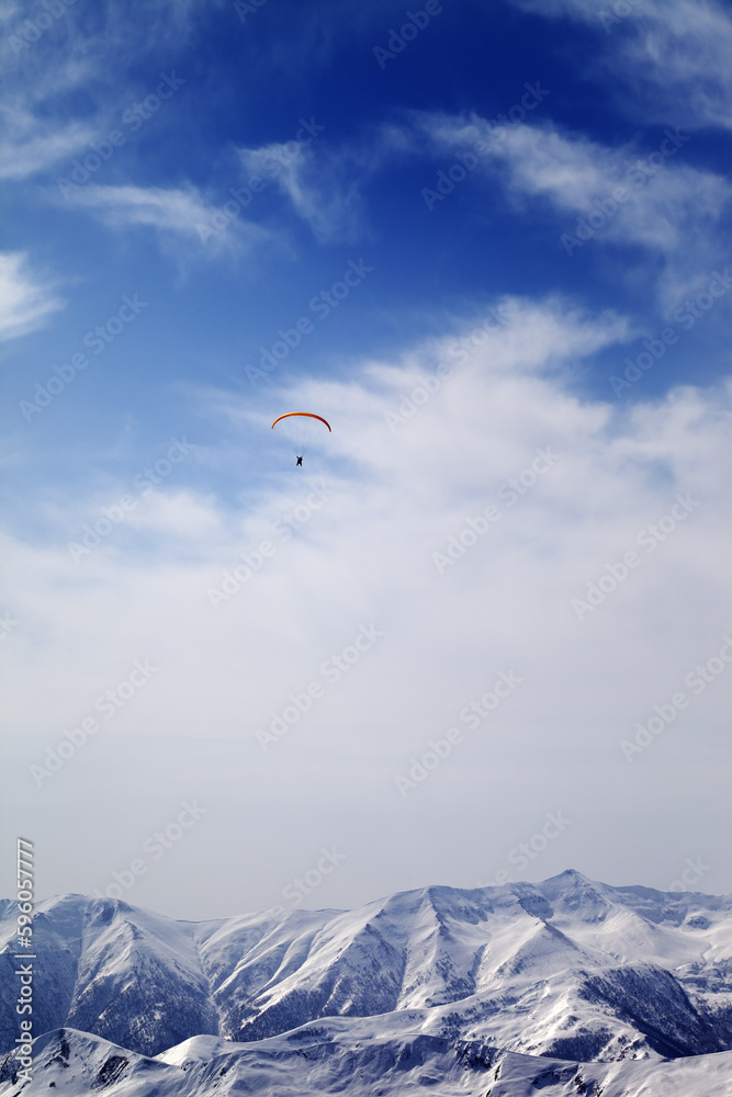 Sunlight mountain with clouds and silhouette of paraglider Sunlight mountain with clouds and silhouette of paraglider
