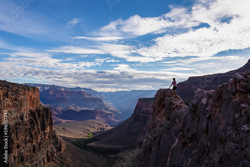 Silhouette of woman standing on edge of rock formation overlooking the South Rim of National Park, Arizona, USA, America. Aerial views on Bright Angel and Plateau Point hiking trail in summer. Freedom © Chris