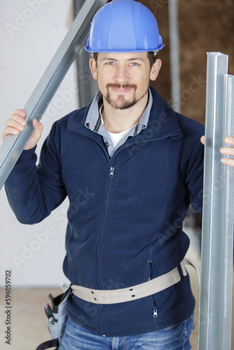 portrait of builder holding aluminium frames photo