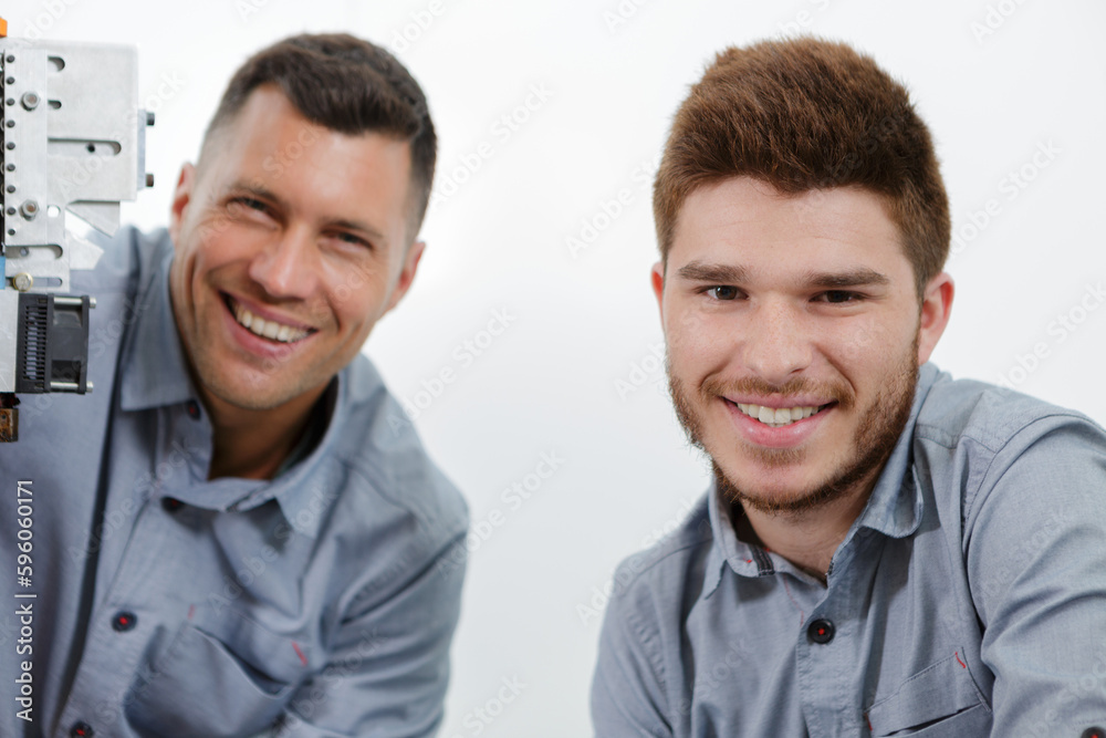 portrait of electrician with apprentice looking at the camera portrait of electrician with apprentice looking at the camera