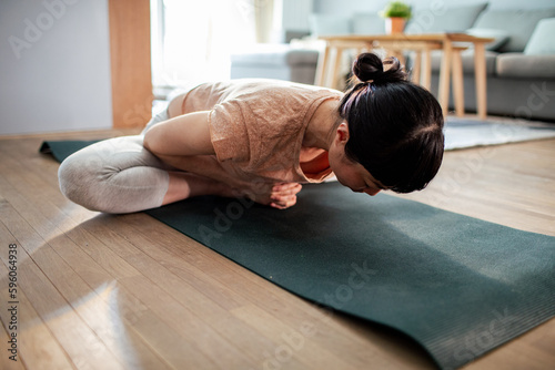 Young Japanese woman doing yoga at home
