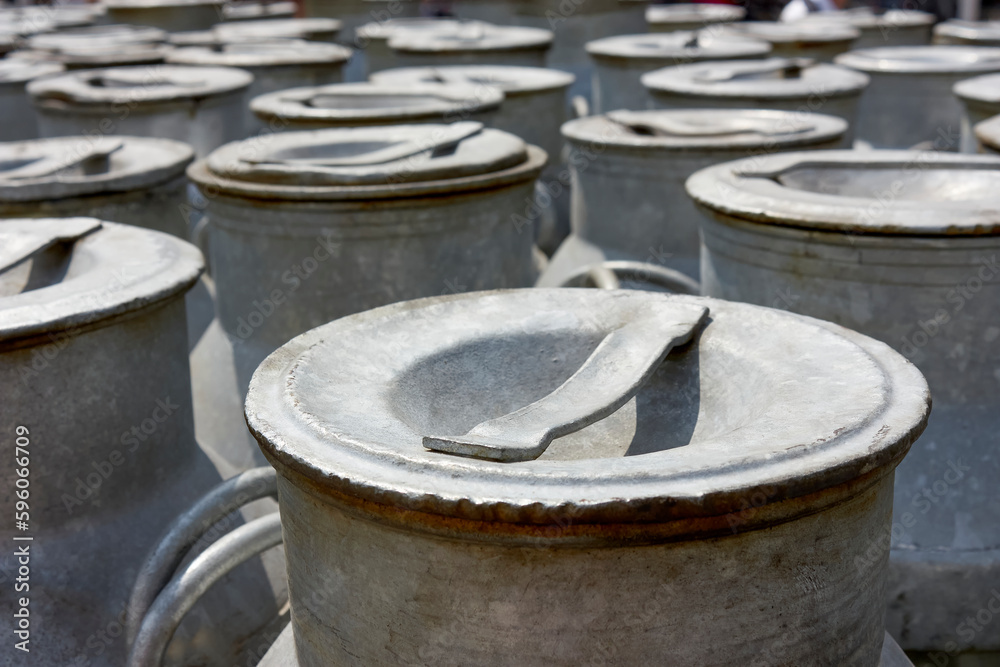 Many old-fashioned iron milk churns with lids in Friesland The Netherlands. Image with selective focus. Many old-fashioned iron milk churns with lids in Friesland The Netherlands. Image with selective focus.