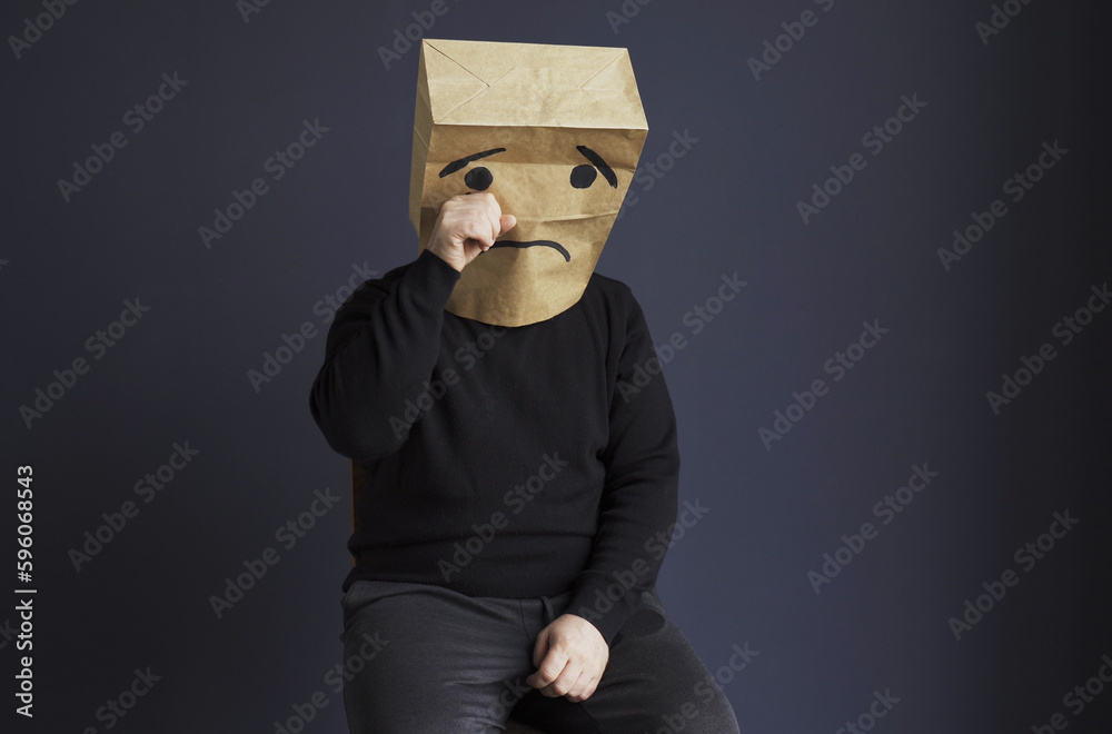 Sad man with a bag on his head, with a drawn crying emoticon. - obrazy, fototapety, plakaty 