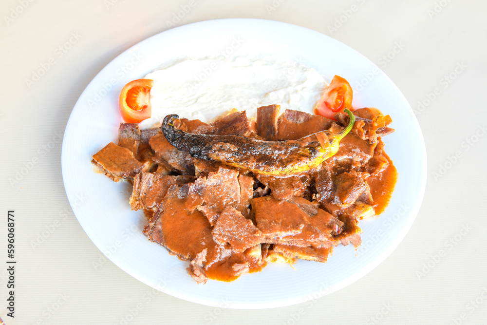 Traditional turkish iskender kebab in copper plate with yogurt, grilled tomatoes and fresh vegetables. Traditional turkish iskender kebab in copper plate with yogurt, grilled tomatoes and fresh vegetables.