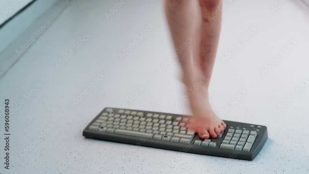 Vidéo Stock child stands, jumps, dances with his feet on computer