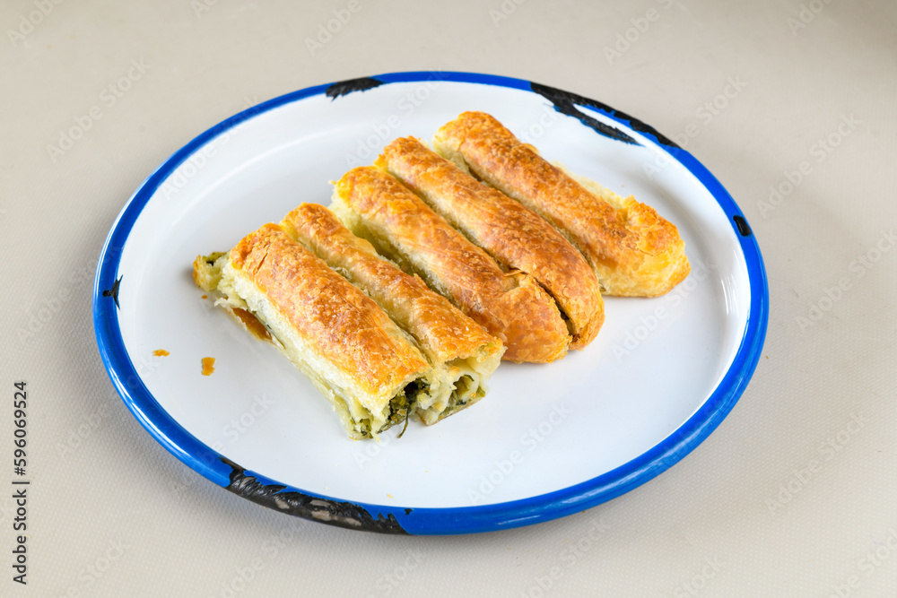 Turkish style meat stuffed filo dough borek served kol boregi. Cheese and minced pie are sliced on a marble background. Turkish name: Kol Boregi, ispanakli, kiymali, Su Boregi Turkish style meat stuffed filo dough borek served kol boregi. Cheese and minced pie are sliced on a marble background. Turkish name: Kol Boregi, ispanakli, kiymali, Su Boregi