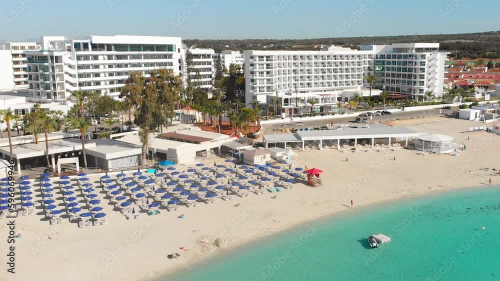Ayia Napa, Cyprus - 15th april, 2023: aerial fly over Luxury hotel buildings with pools by beach with island greenery panorama.White sand most famous in Cyprus - Nissi beach Ayia Napa, Cyprus - 15th april, 2023: aerial fly over Luxury hotel buildings with pools by beach with island greenery panorama.White sand most famous in Cyprus - Nissi beach