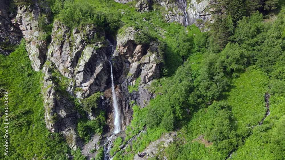 Aerial view of waterfall in green alpine mountains Aerial view of waterfall in green alpine mountains