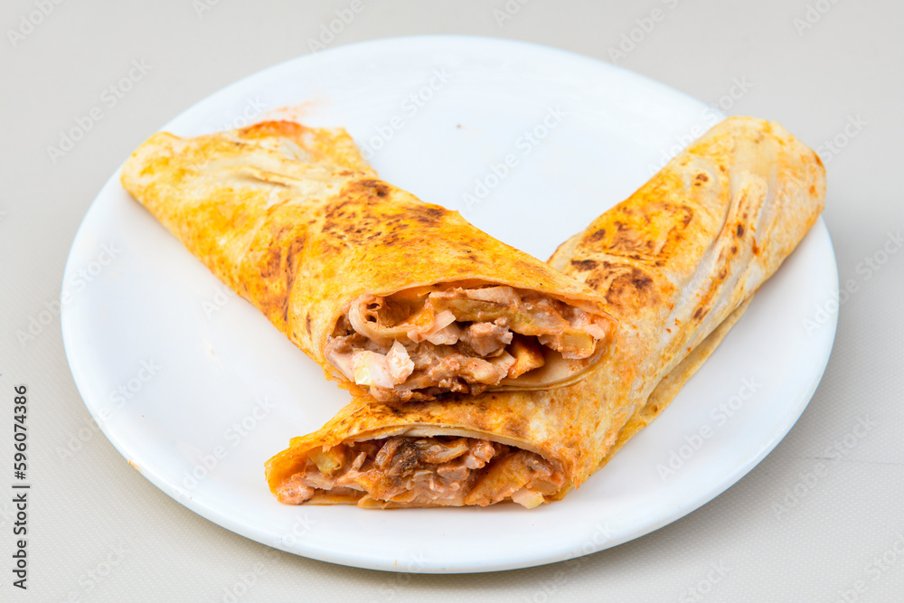 Lavash doner kebab ( zurna doner durum ) or shawarma sliced in plate isolated. Lavash doner kebab ( zurna doner durum ) or shawarma sliced in plate isolated.