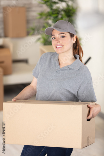 charming smiling deliverywoman holding parcel photo