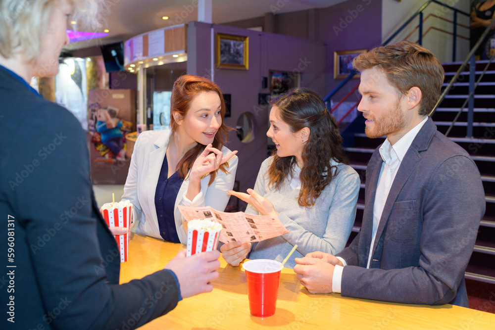friends socializing in a cinema lobby lounge friends socializing in a cinema lobby lounge