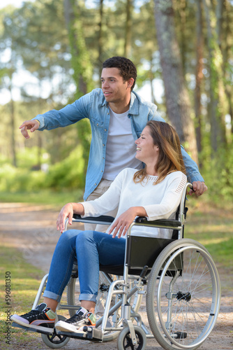 couple with wheelchair in autumn forest