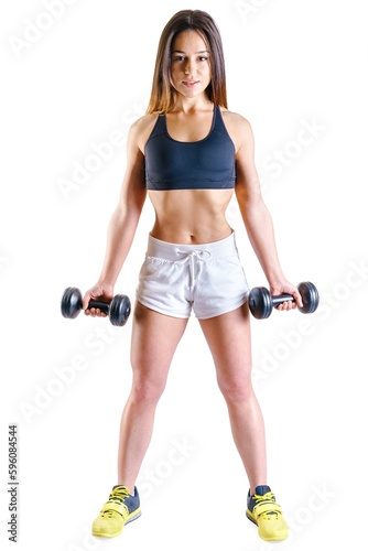 Young bodybuilder happy healthy woman lifting two dumbbells beautiful fitness sporty girl showing her well trained body well-developed muscles by strength training yellow sneakers trainers shoes