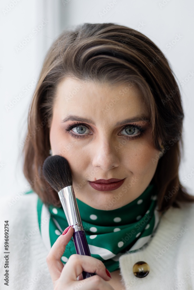 Close up portrait of attractive beautiful woman with the make up brush near her face. Professional artist at work Close up portrait of attractive beautiful woman with the make up brush near her face. Professional artist at work