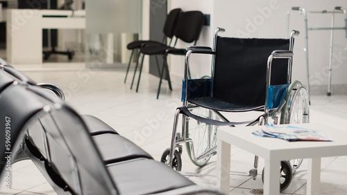 Wheelchair in empty diagnostic center used to cure disease and give prescription medicine. Hospital reception waiting room with seats and recovery equipment, disability friendly.
