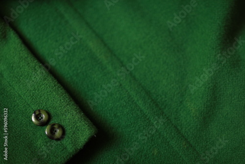 Buttons on a green coat, button, text, day, work, sewing, sewing factory, hobby, learning, sew, tailoring, dressmaker, cut,close up of green fabric,green jacket sleeve, wool fabric, cashmere, outerwea