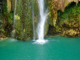 Close-up photo of the end of the Sillans-la-Cascade waterfall in the Var department in Provence in France falling into an expanse of turquoise blue colored water reminiscent of a lagoon