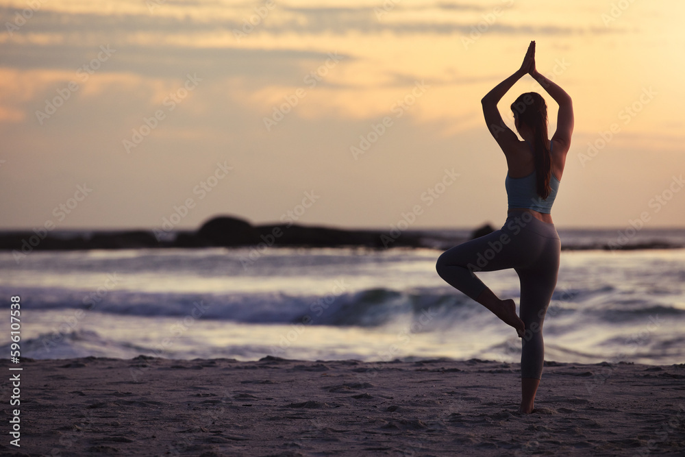 Be mindful of your movements. a unrecognizable female doing yoga at the beach.