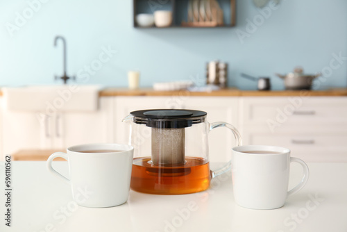 Glass teapot with two white...