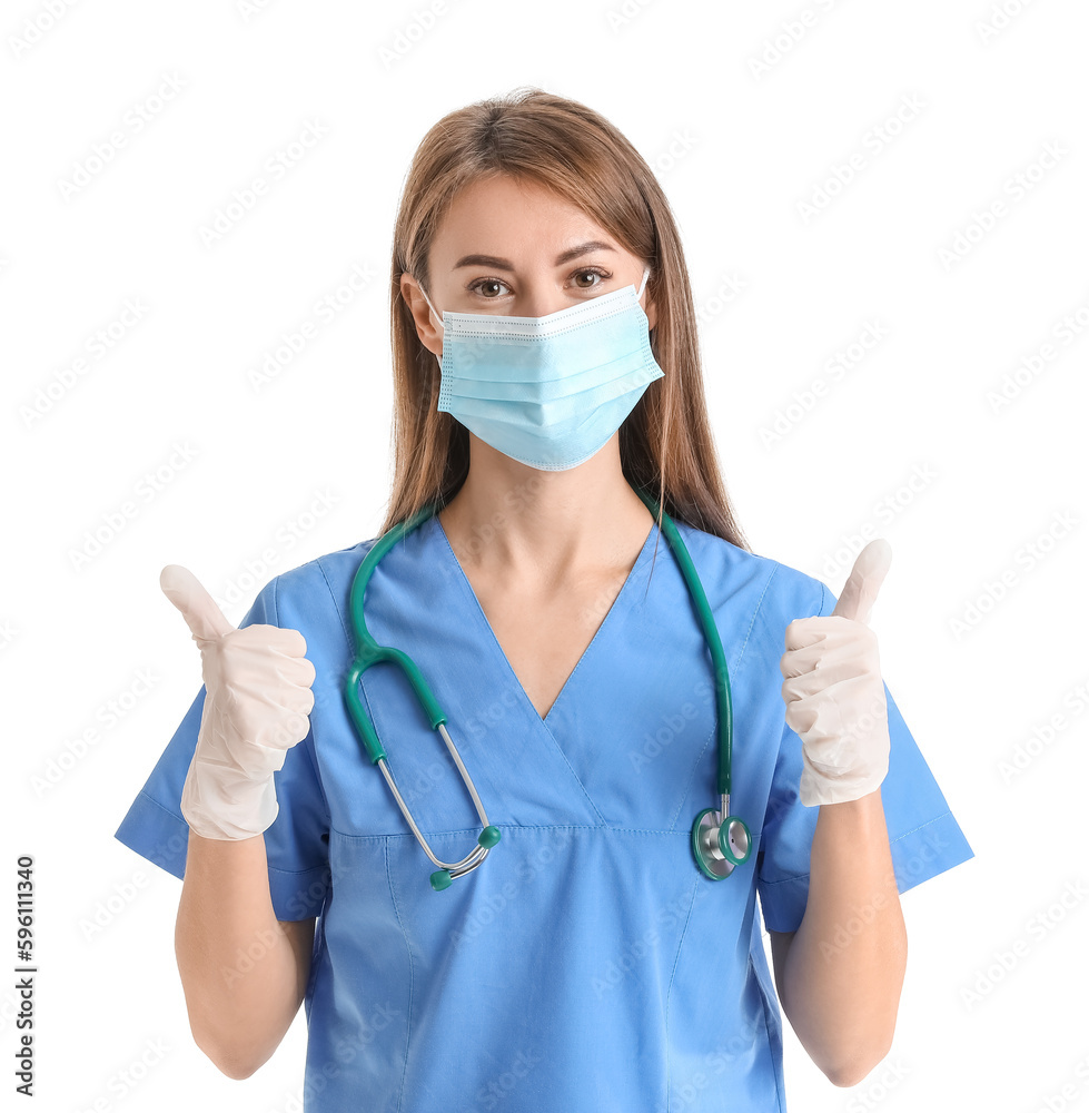 Female medical assistant in mask showing thumbs-up on white background Female medical assistant in mask showing thumbs-up on white background