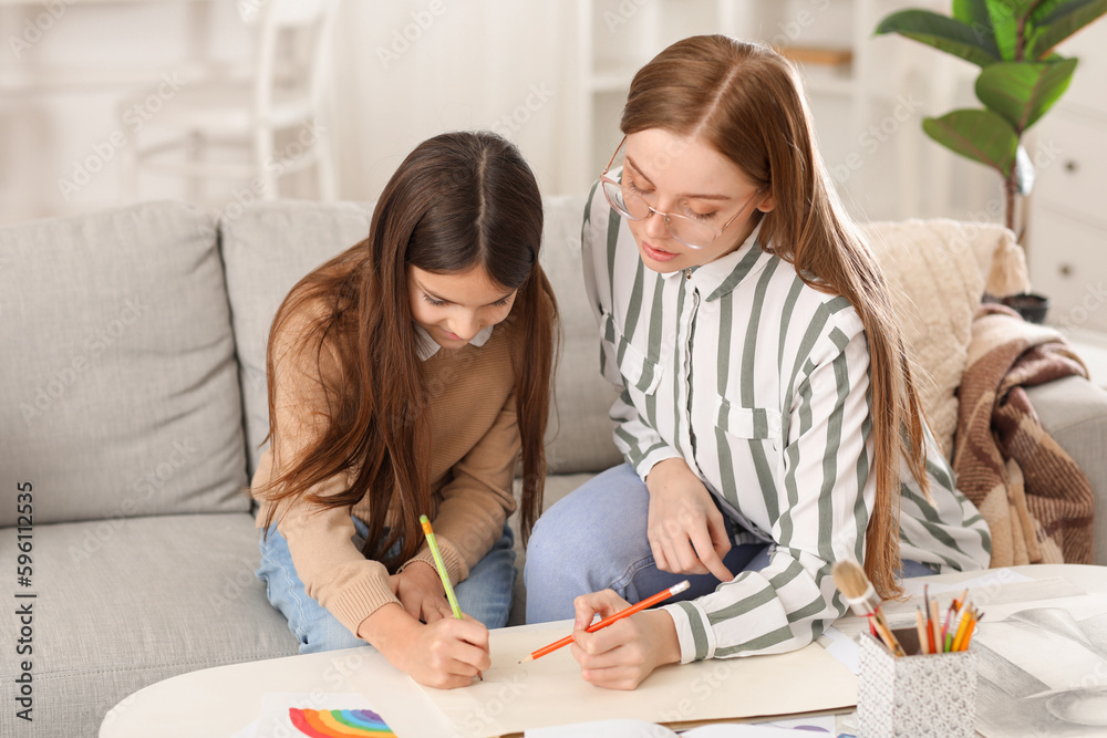 Drawing teacher giving private art lesson to little girl at home Drawing teacher giving private art lesson to little girl at home