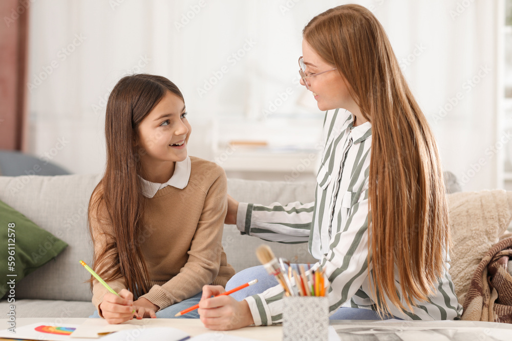 Drawing teacher giving private art lesson to little girl at home Drawing teacher giving private art lesson to little girl at home