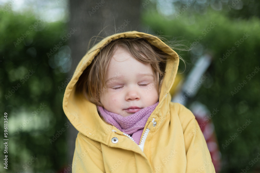 Little girl in yellow jacket feeling cold outside