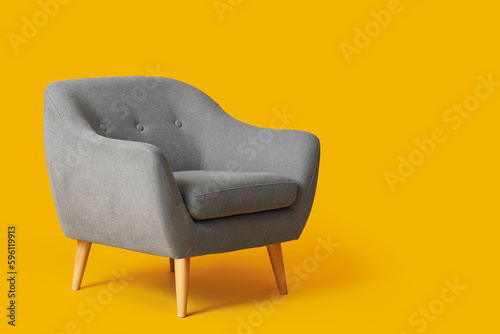 Cozy grey armchair on orange background