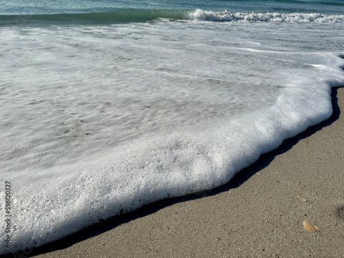 Ocean waves, foam on the sand