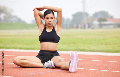Races can be won or lost before the start. Full length portrait of an attractive young female athlete going through her warmups out on the track.