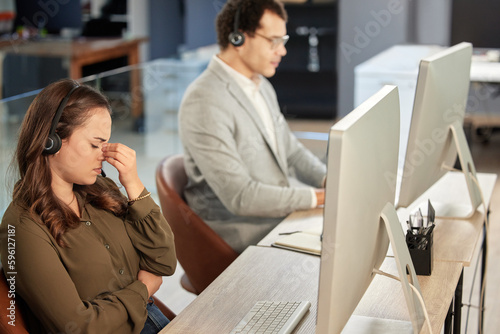 Im not ready to tackle this issue. a young call centre agent looking stressed out while working in an office alongside a colleague.