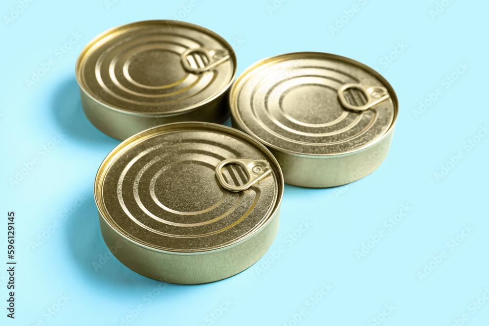 Tin cans with fish on blue background Tin cans with fish on blue background