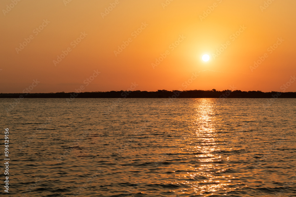 Sunrise at Bacalar lagoon , the sun light is reflect on the lagoon water , Rivera maya , Mexico