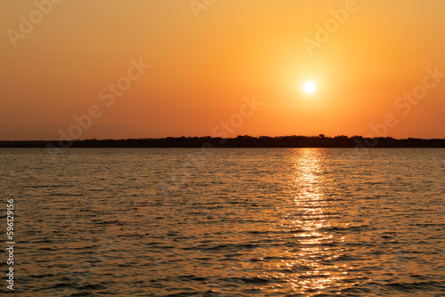Sunrise at Bacalar lagoon , the sun light is reflect on the lagoon water , Rivera maya , Mexico
