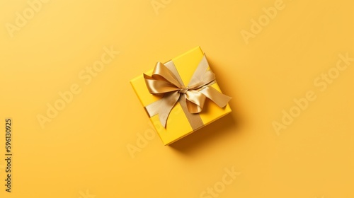 Photographie Golden ribbon gift box on yellow background, copy space, birthday/Christmas present, flat lay, top view concept