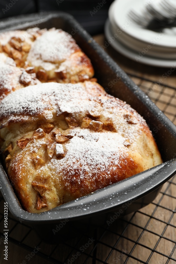 Delicious yeast dough cake in baking pan on wooden table, closeup