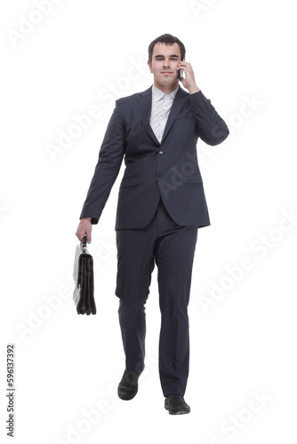 handsome young business man talking on a mobile phone and holding a suitcase on white background