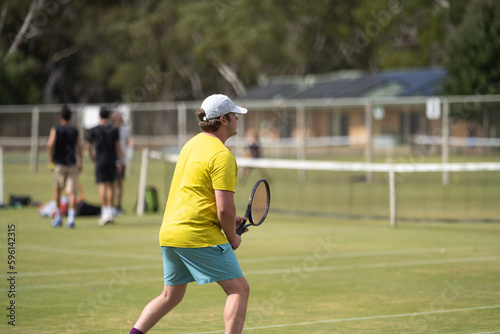 Amateur playing tennis at a tournament and match on grass in Europe 