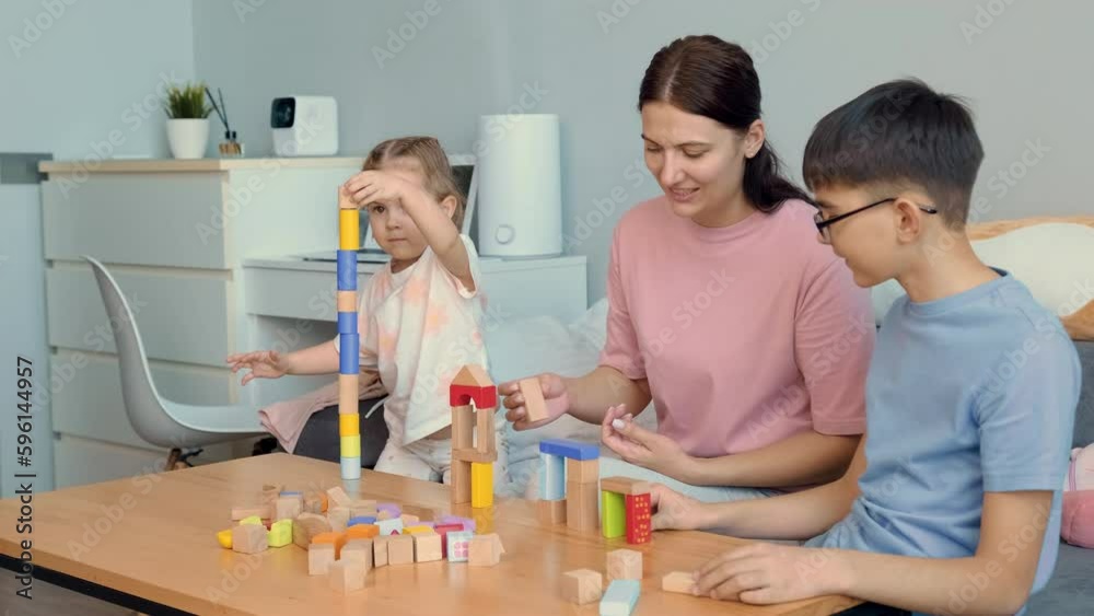 Mom and children build structures from wooden blocks at home.Mothers Day,Family Games,Home Education,Educational Games