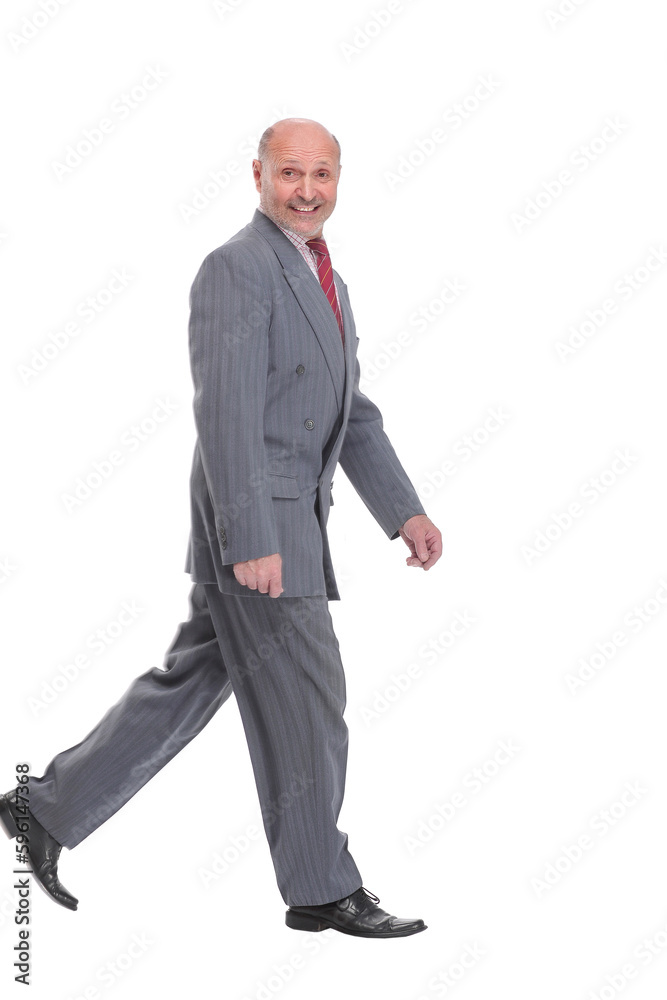 side view full length photo of a mid aged business man walking forward and looking away side view full length photo of a mid aged business man walking forward and looking away