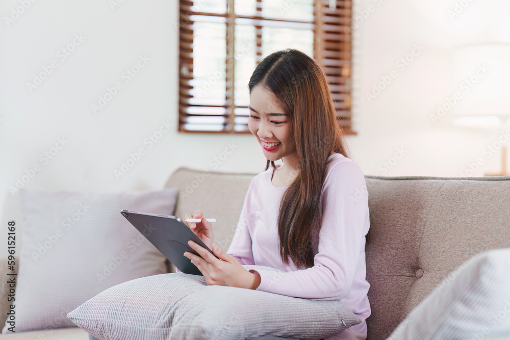 Attractive Asian woman resting comfortable living room and using digital tablet, Relax, Sofa, Lifestyle Attractive Asian woman resting comfortable living room and using digital tablet, Relax, Sofa, Lifestyle