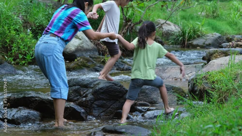 Family camping outdoor, Mother and daughters playing in the river. Mother and daughter go on an adventurous vacation trip together. Healthy lifestyle and eco-tourism. Family camping outdoor, Mother and daughters playing in the river. Mother and daughter go on an adventurous vacation trip together. Healthy lifestyle and eco-tourism.