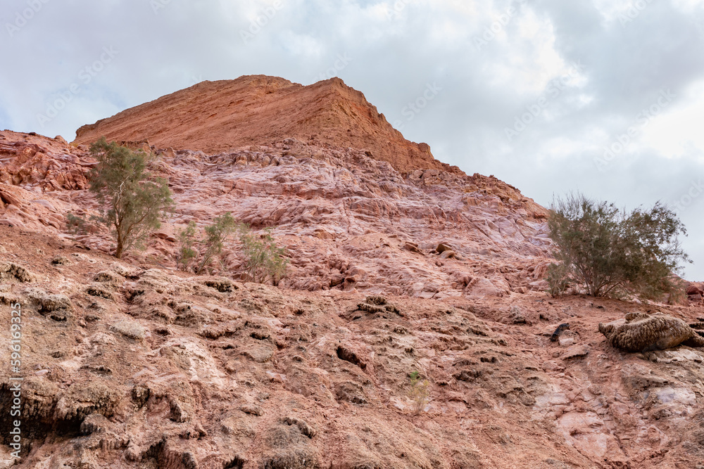 Fototapeta premium Red mountains containing a lot of copper surround the deep blue Hidden Lake near the Timna park,surrounded by mountains near Eilat city, Arava Valley, southern Israel