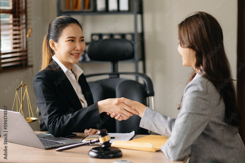 © Nuttapong punna - Woman lawyer hand and women client shaking hand collaborate on working agreements with contract documents at the modern office. © Nuttapong punna - Woman lawyer hand and women client shaking hand collaborate on working agreements with contract documents at the modern office.