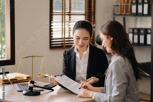 Judge gavel with scales of justice, Business and lawyer or counselor consulting and discussing contract papers with laptop and tablet at law firm in office.
